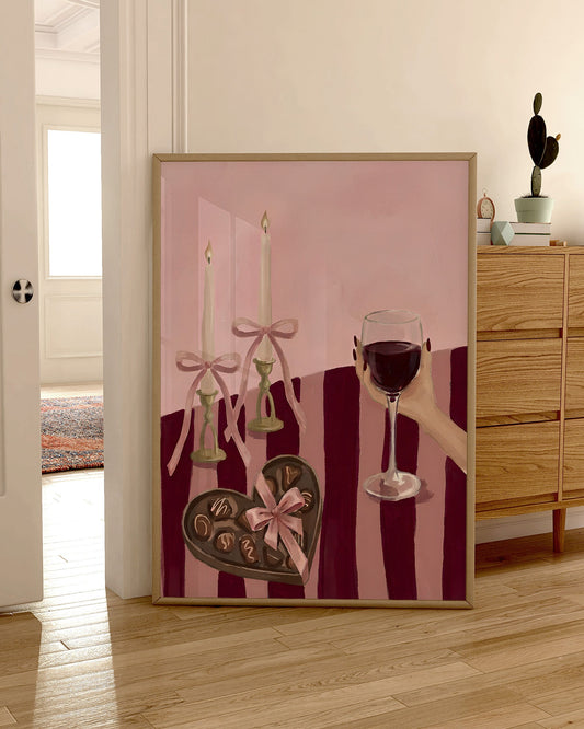 Decorative wall art with a pink background, candles, and a heart-shaped chocolate in a room with wooden furniture.