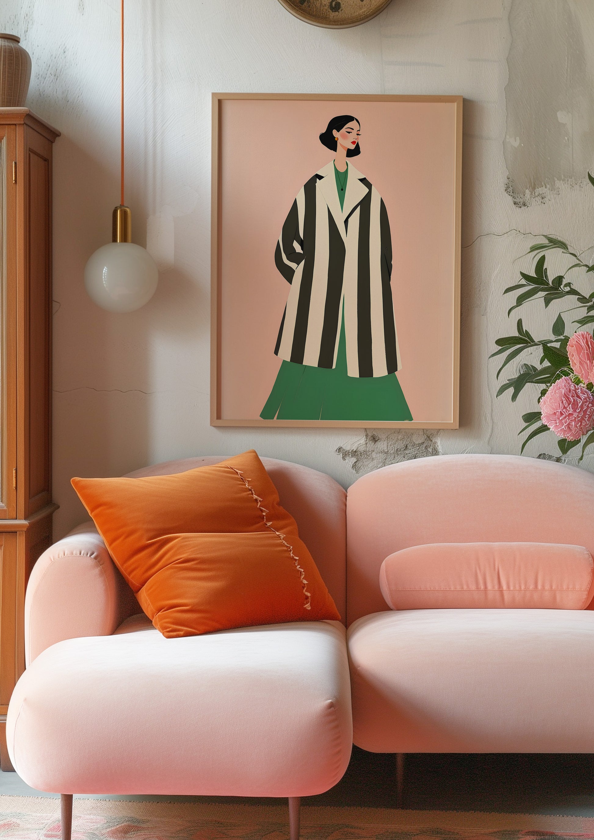 Pink armchair with orange pillow and framed artwork on wall