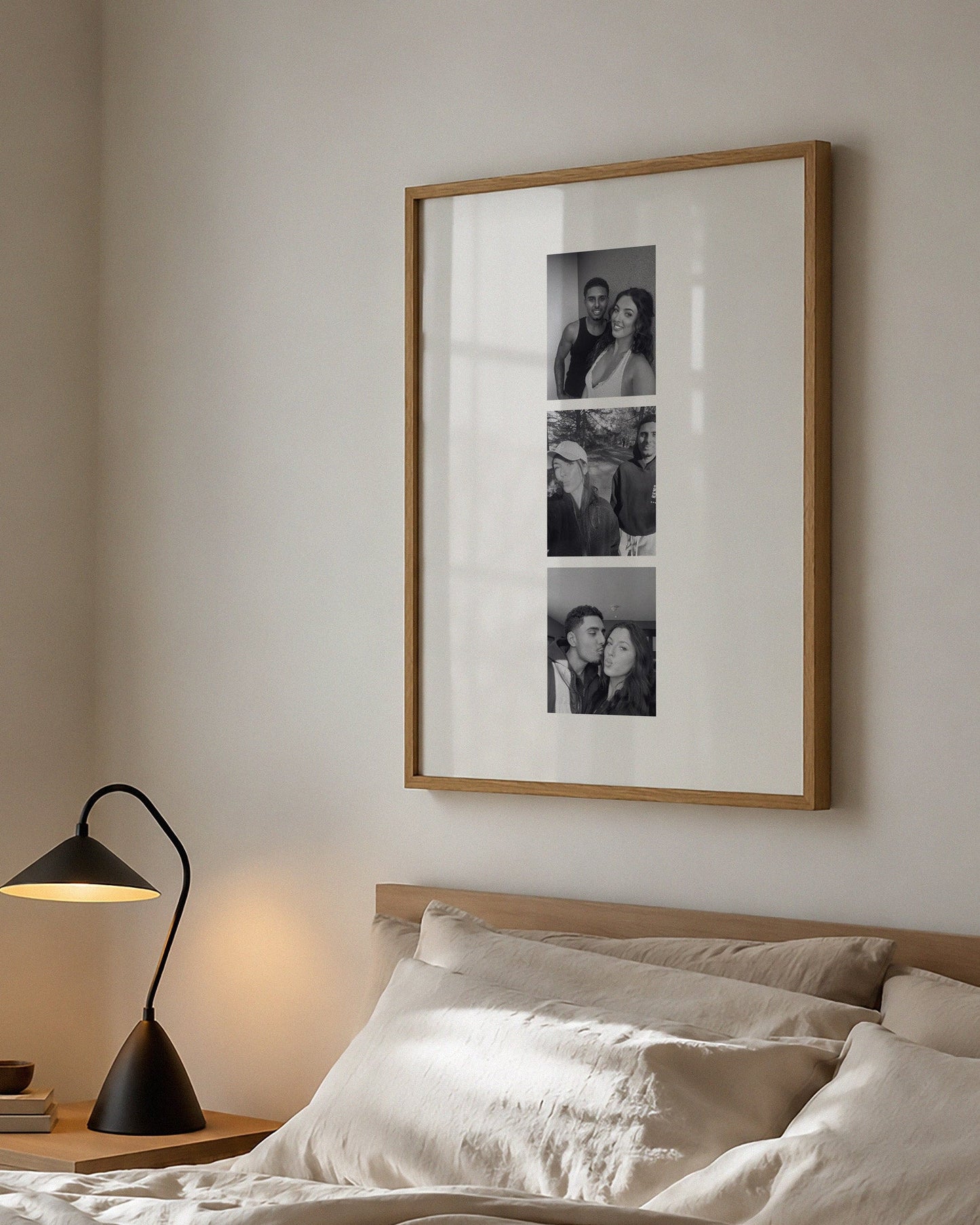 Bedroom with framed artwork above a bed and lamp on a nightstand.