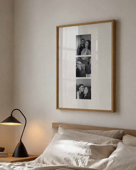 Bedroom with framed artwork above a bed and lamp on a nightstand.